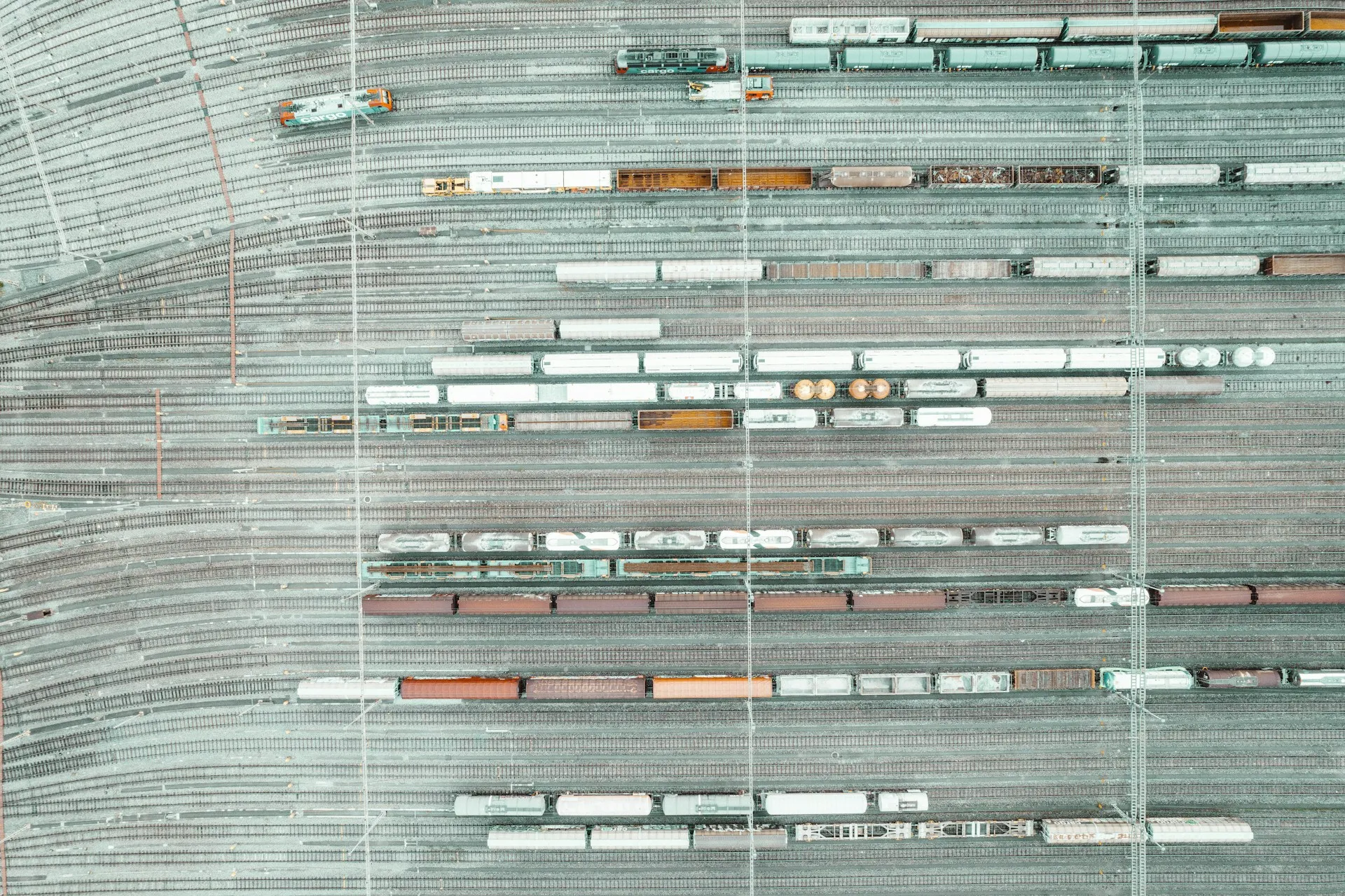 Like a switching yard, DMR sends each event down the track its subscribers asked for, and an event nobody asked for never leaves its home site. Aerial view of a rail switching yard with many tracks and parked freight cars