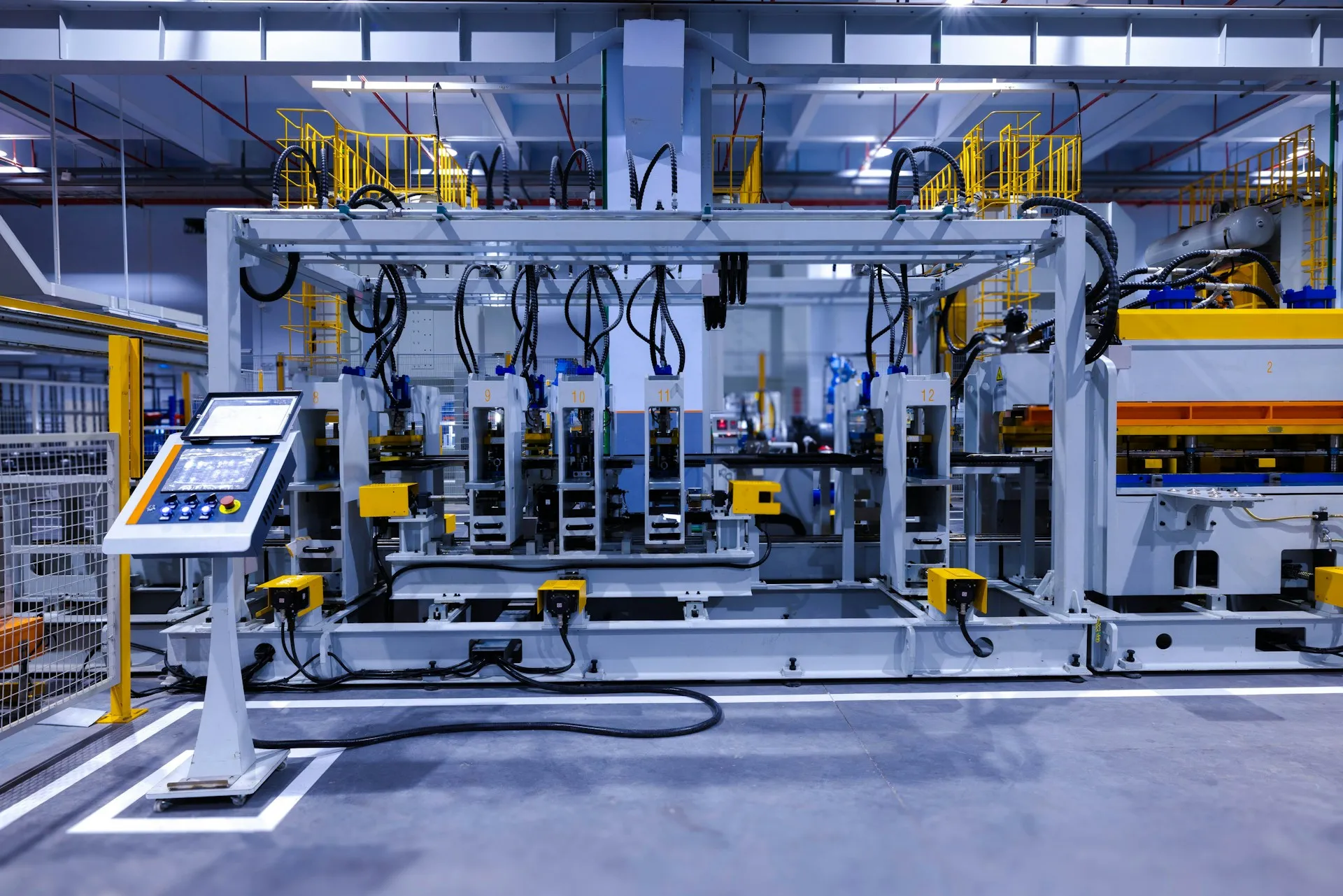 The HMI at the cell is the UNS made visible. It must keep working when the WAN does not, which is why the site keeps its own broker under any mesh. Pedestal-mounted operator touch panel with push buttons beside an automated production cell