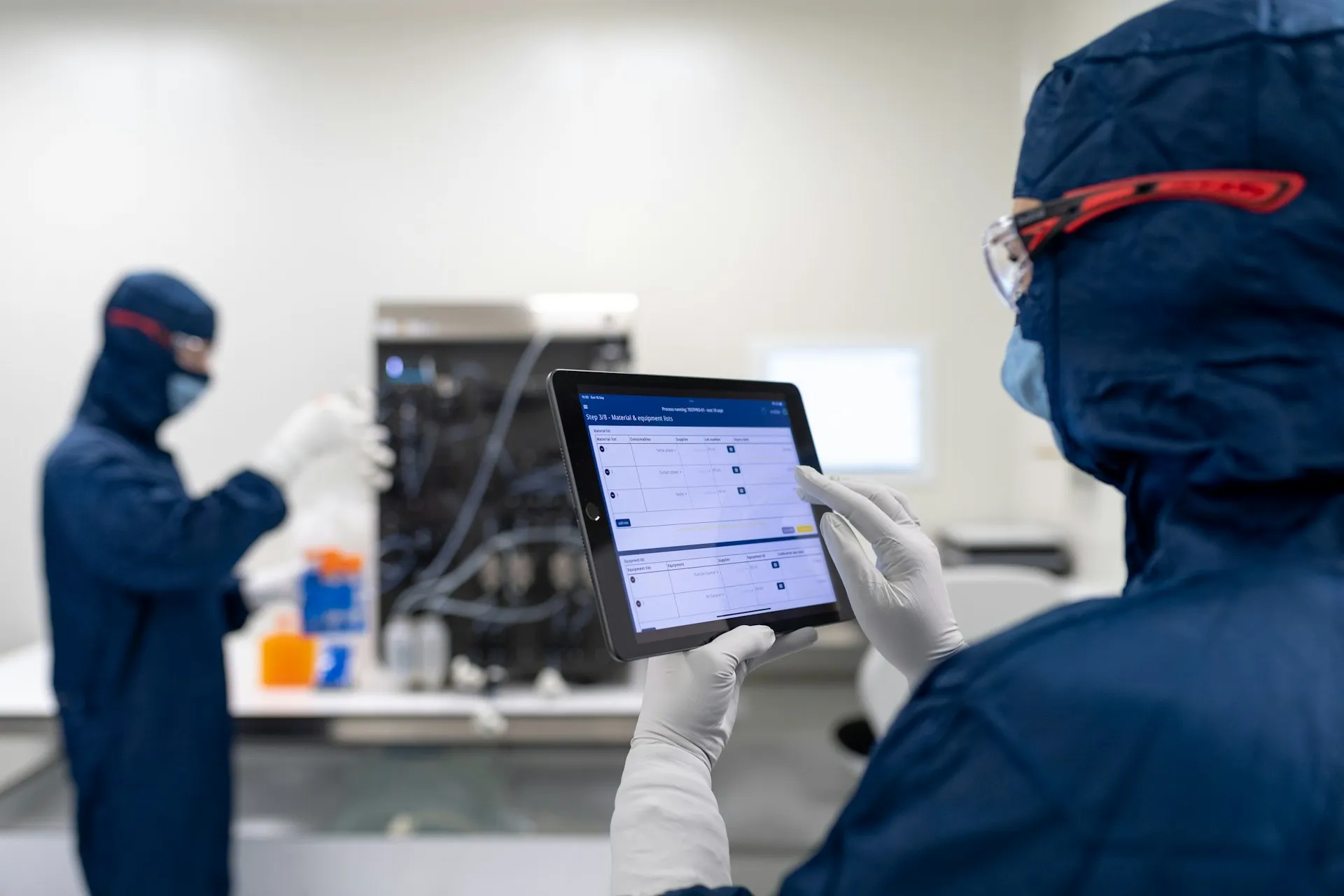 The UNS broker is invisible until a screen freezes. Size it for the consumers it will have in two years, not the dashboard that started the project. Operator in cleanroom gown holding a tablet showing a batch step screen while a colleague works behind