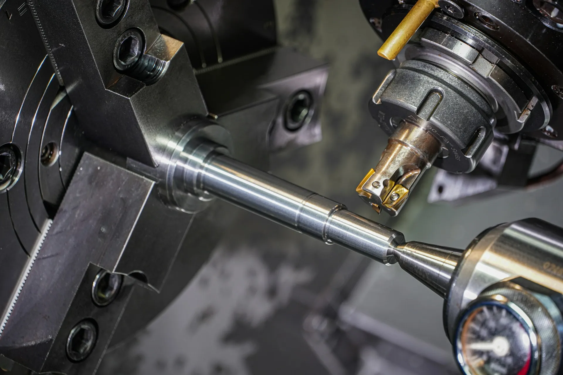 A machine tool with no network uplink still holds programs and offsets worth days of work, and only a person on a schedule will back it up. Close-up of a CNC lathe cutting tool turning a polished steel shaft