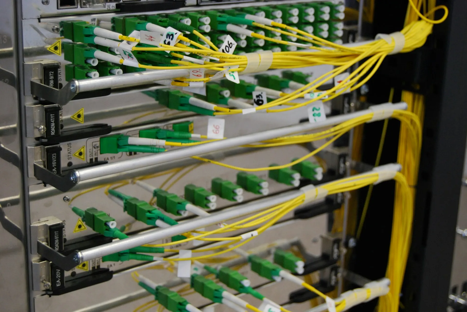 Fibre between areas and buildings buys distance, noise immunity and faster ring recovery. Yellow fibre patch cords terminated on a labelled optical distribution frame