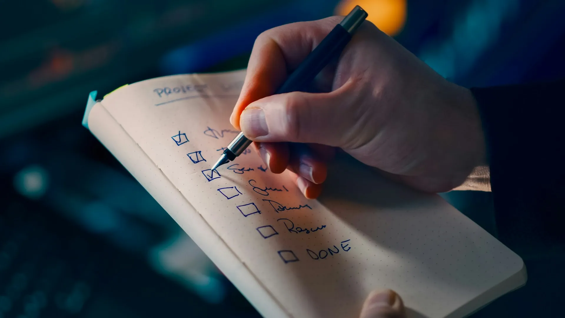 Acceptance criteria turn done into a checklist both sides sign before the test, instead of an argument at the end of the project. Hand with a pen ticking boxes on a handwritten project checklist in a notebook