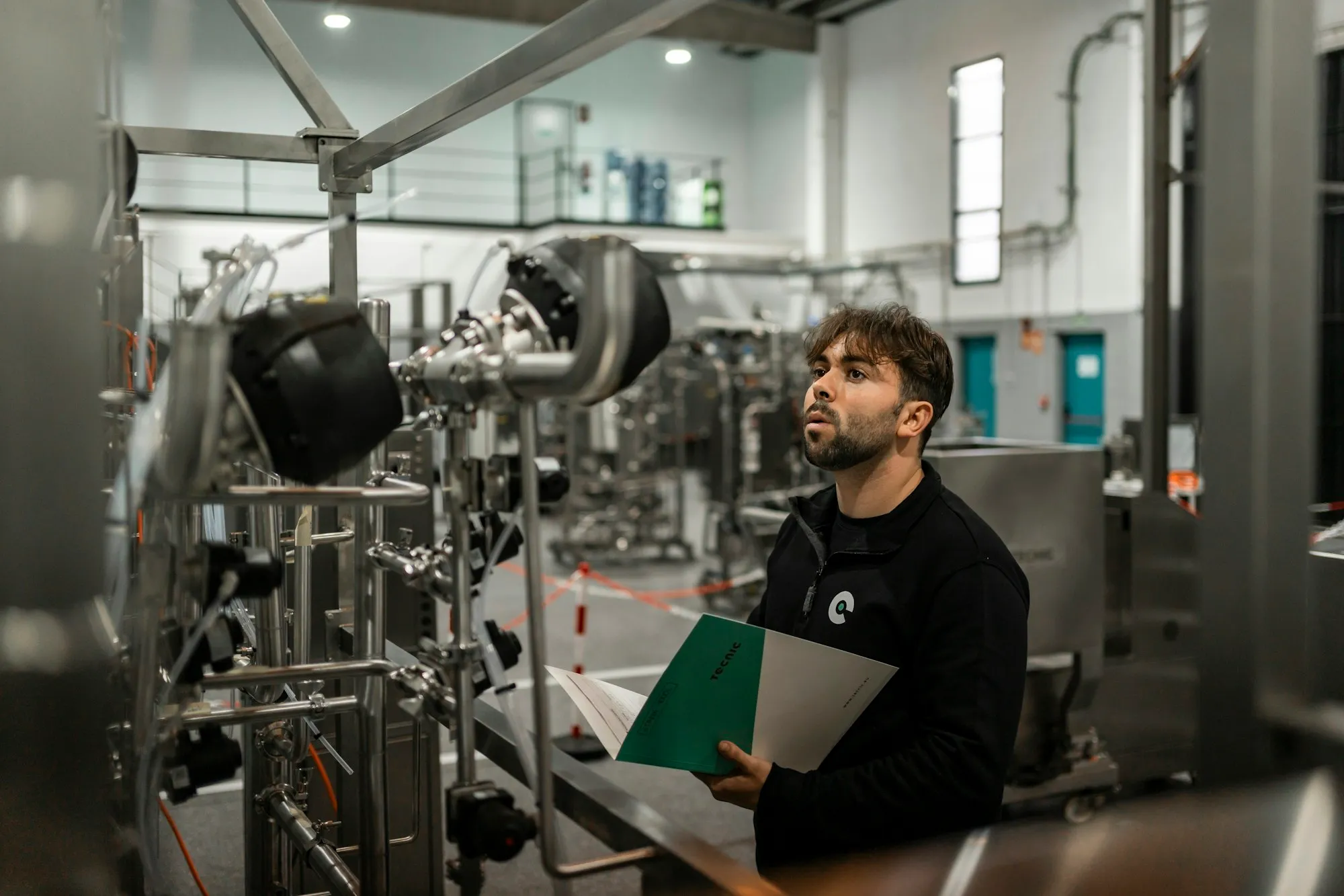 An engineer inspecting process equipment on a plant floor