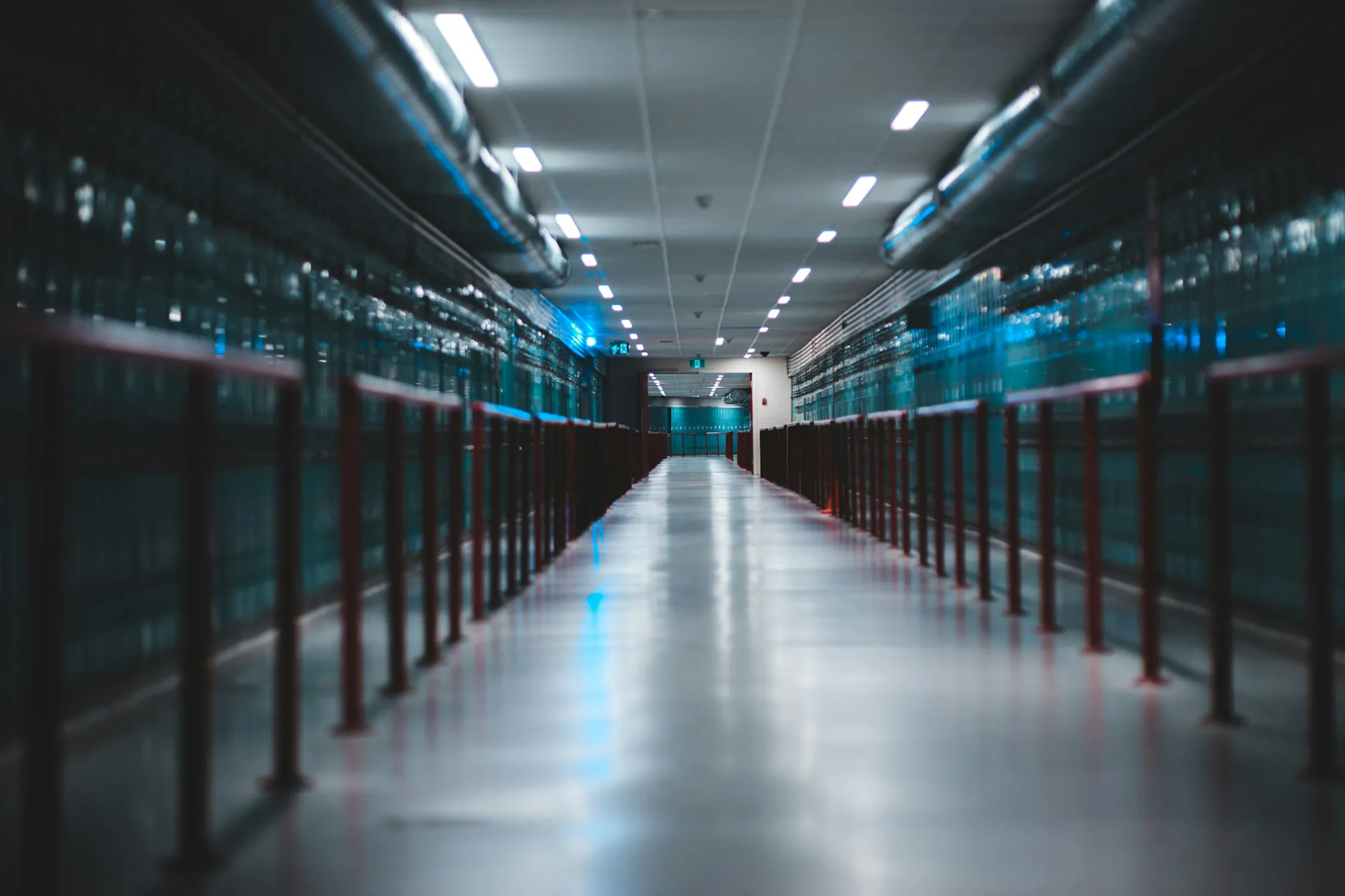 Whichever edition you buy, the broker ends up as infrastructure in a hall like this, and someone has to own its patching, capacity and failover. Long, brightly lit corridor lined on both sides with equipment cabinets and railings