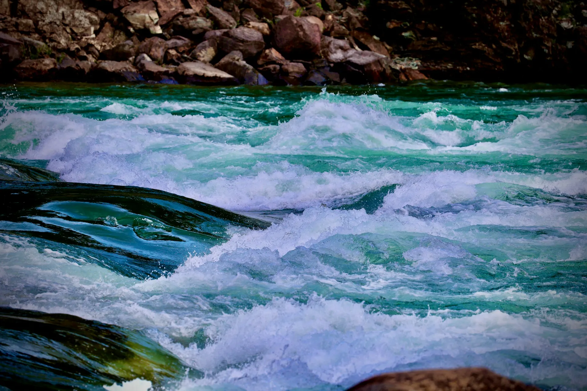Bridge only the streams you need: every topic sent to Kafka is retained and paid for there, so choose topics deliberately rather than mirroring everything. Rushing river with green water and white foamy rapids flowing past rocks