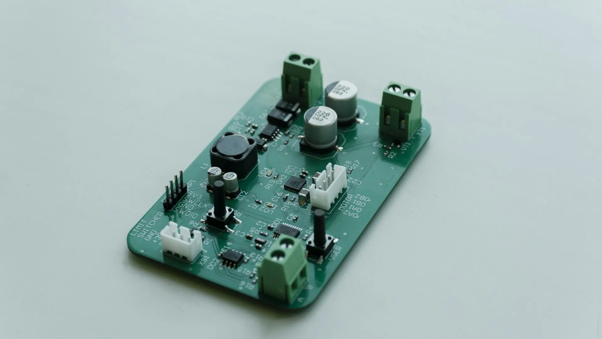 Most plant MQTT traffic comes from small gateways like this one; they need QoS 0 or 1, not QoS 2, so the downgrade rarely matters if consumers handle duplicates. Small green circuit board with screw terminals and connectors on a pale surface