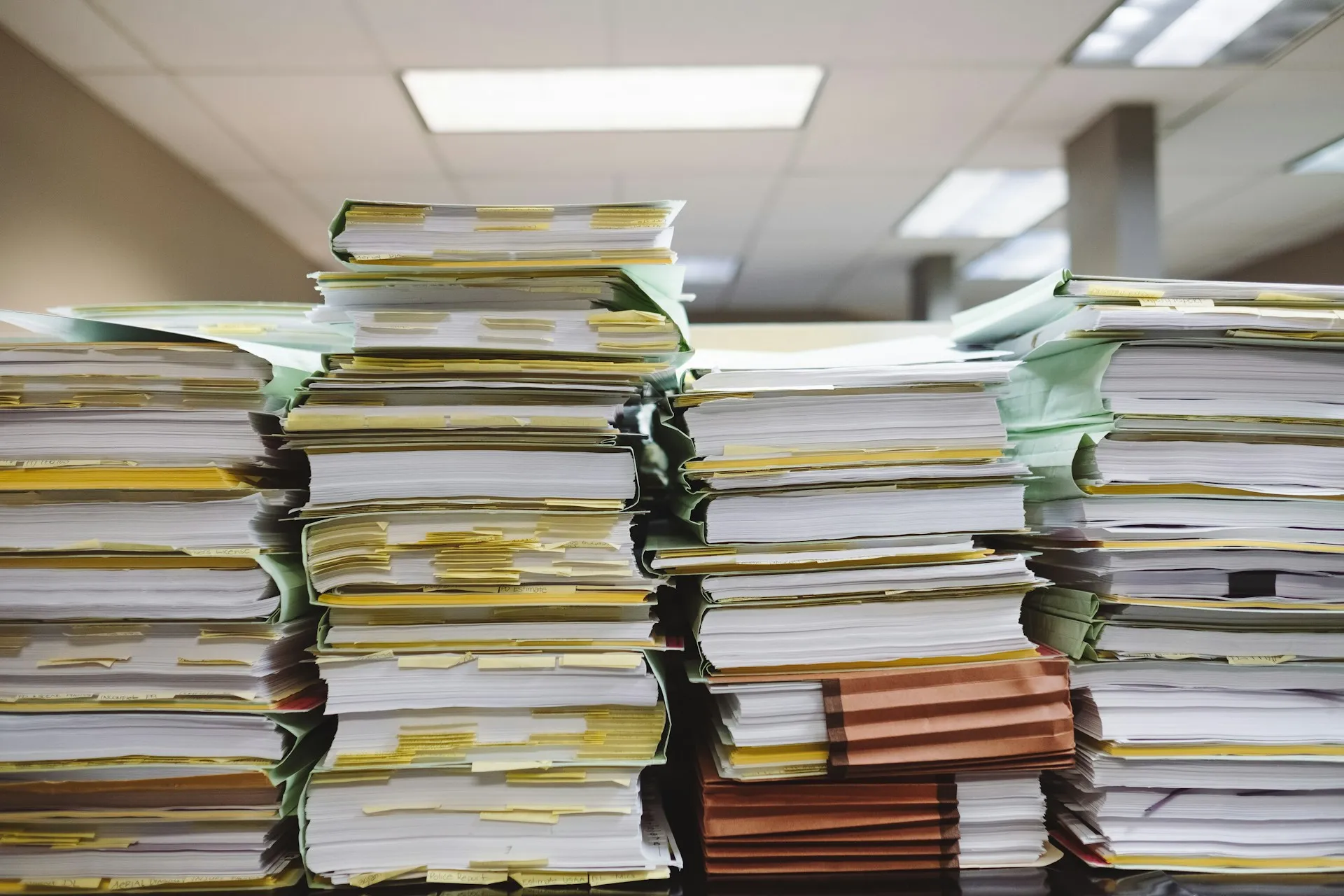 Replay only reaches as far back as the archive goes. The quota you set decides whether that is two hours or two weeks. Tall stacks of paper files and folders piled on desks in an office