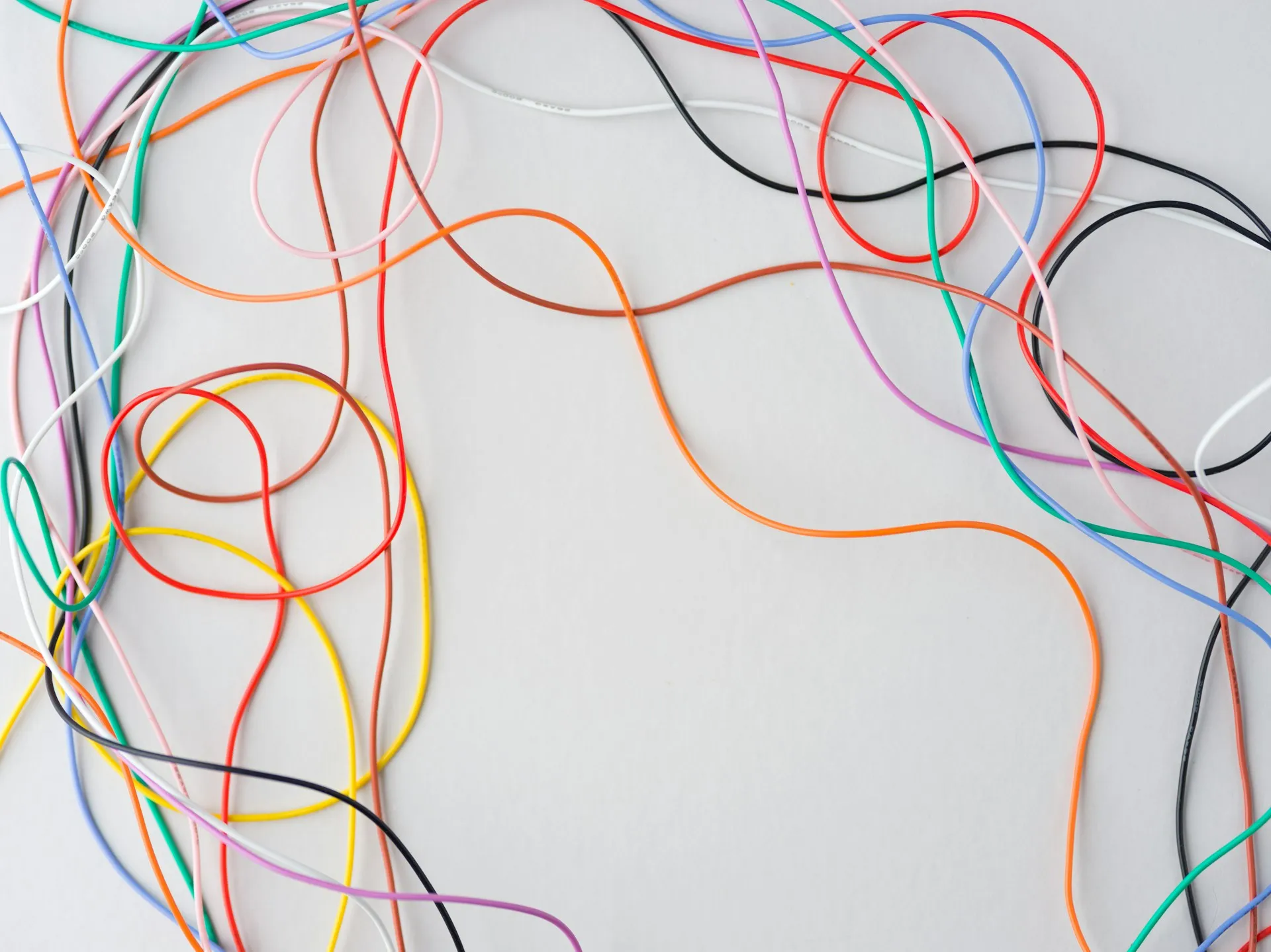 Loose coloured hookup wires tangled across a plain white surface