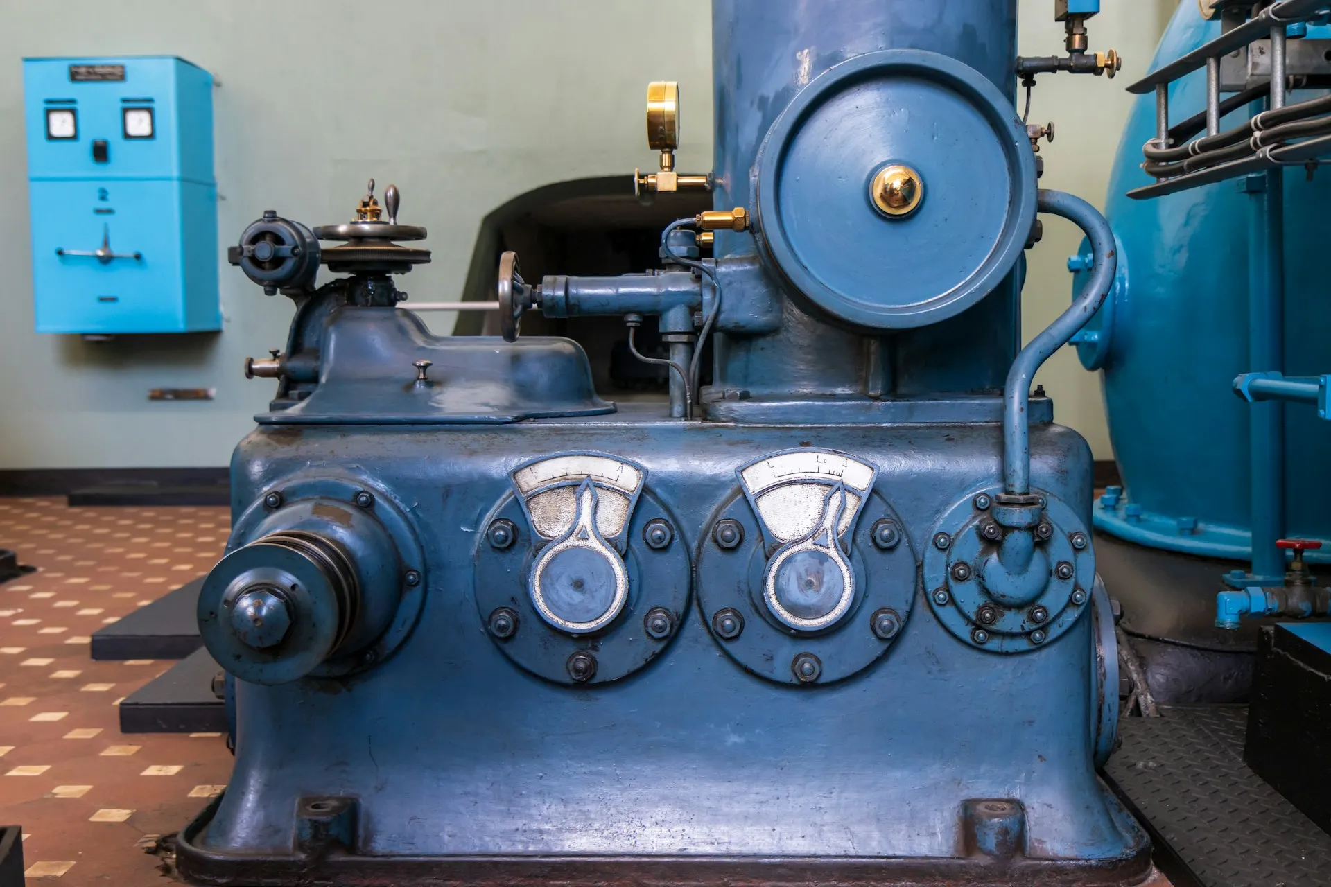 Utility plant stays in service for generations. The value case there is knowing what runs on old, scattered equipment and putting it back, not shaving minutes off a high-volume line. Vintage blue pump engine with dial gauges in a tiled utility machine hall