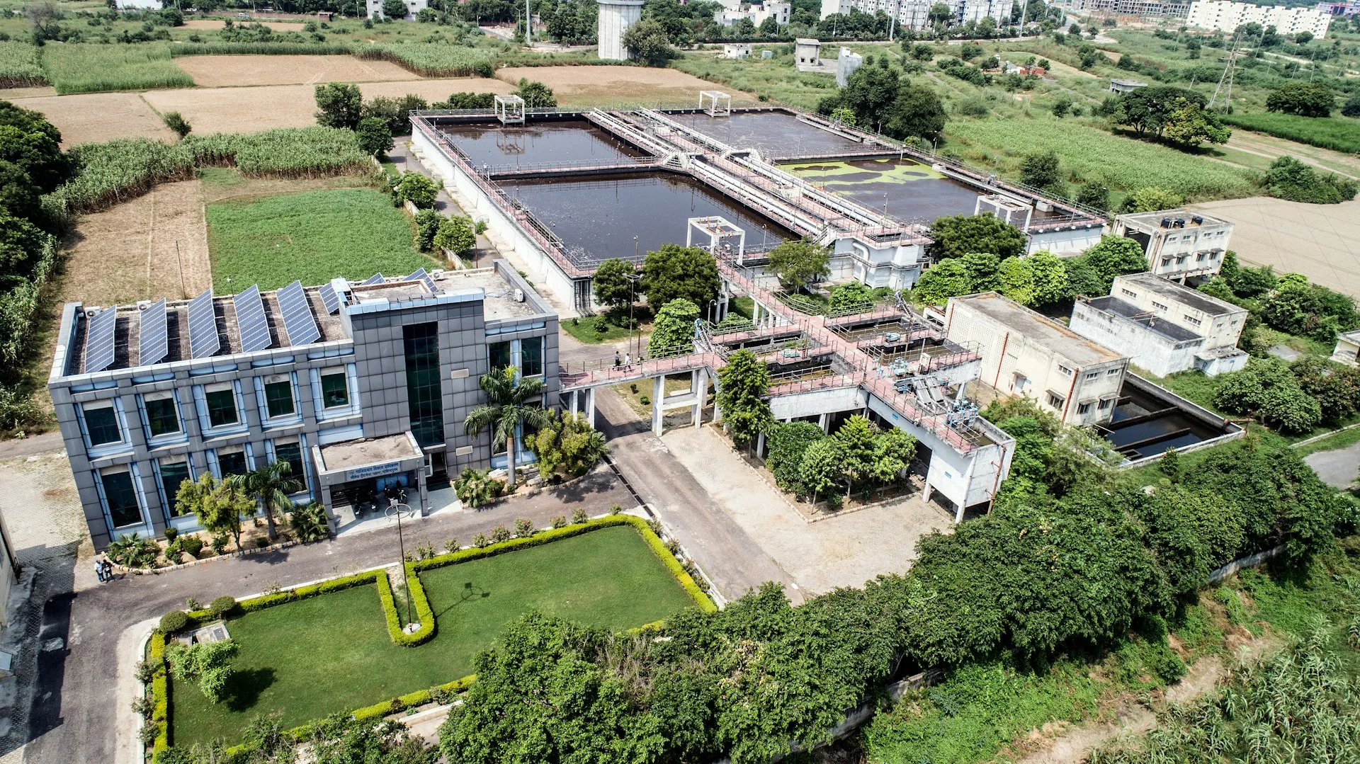 A treatment works is only the hub. The pumping and lift stations it depends on are spread across the region and unstaffed, so the current program has to be retrievable without anyone driving out. Aerial view of a water treatment works with settling basins, filter beds and an operations building