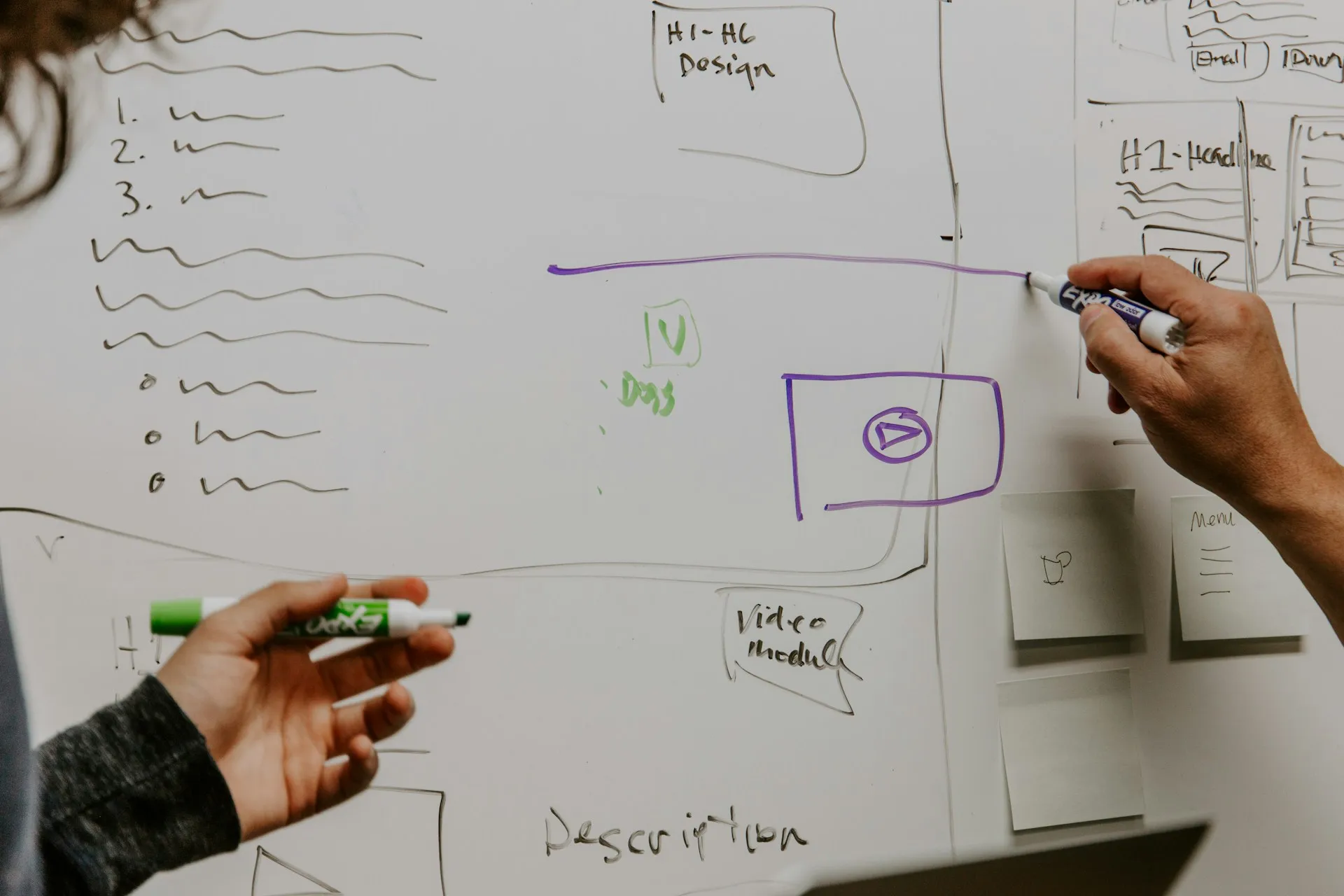 The hard design work is on the whiteboard: which events start an agent, which agent may call which tool, and where a person must approve. Two hands with markers sketching boxes, lists and arrows on a whiteboard during a design session
